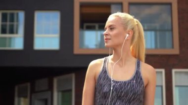 Genç, çekici ve sportif sarışın kız spor açık müzik dinlerken. Sağlık ve yaşam tarzı.