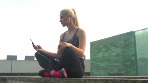 Ung Attraktiv Sporty Blond Jente Sportstøy Hører Musikk Slapper Utendørs – stockvideo