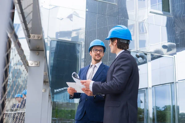 Immobilienentwickler Helmen Büroneubau Selbstbewusste Geschäftsleute Und Architekten Gespräch Vor Modernen — Stockfoto