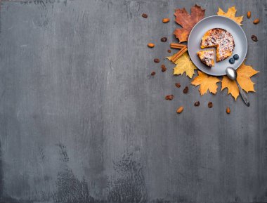 Mevsimlik sonbahar arka planı. Renkli akçaağaç yaprakları ve gri doku üzerinde bir pasta, hindistan cevizi, kek ve tarçın Çerçeve.