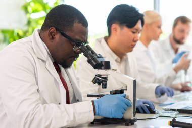 Laboratuvarda çalışan bir bilim adamı. Doktorlar tıbbi araştırma yapıyor. Laboratuvar aletleri: mikroskop, test tüpleri, ekipmanlar. Biyoteknoloji, kimya, bilim, deneyler ve sağlık konsepti. Gün ışığı ve