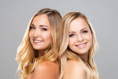 Gri arka plan üzerinde genç, güzel ve doğal sarışın kadınların Stüdyo portresi. Gülümseyen kızların yakın çekim. Yüz germe, plastik cerrahi, kozmetik ve makyaj.