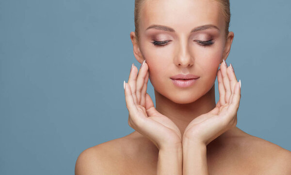 Attractive face of beautiful girl. Close-up portrait of healthy woman. Skin care, cosmetics, makeup, complexion and face lifting.