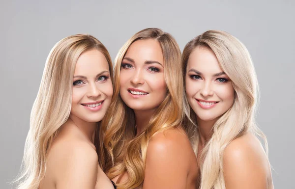 Studio portrait of young, beautiful and natural blond women over grey background. Close-up of smiling girls. Face lifting, plastic surgery, cosmetics and make-up. — Stock Photo, Image