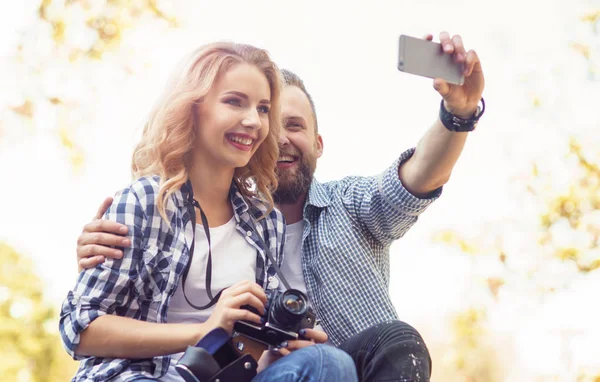 Jovem casal amoroso fazendo foto selfie no parque de outono . — Fotografia de Stock