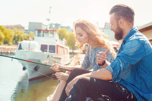 Homem a ensinar a namorada a pescar. Data, amor e conceito hobby. Fundo de outono . — Fotografia de Stock
