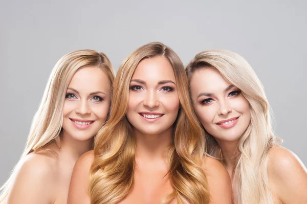 Studioporträt junger, schöner und natürlicher blonder Frauen vor grauem Hintergrund. Nahaufnahme lächelnder Mädchen. Facelifting, plastische Chirurgie, Kosmetik und Make-up. — Stockfoto