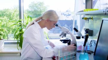 Laboratuvarda çalışan bir bilim adamı. Kadın doktor tıbbi araştırma yapıyor. Laboratuvar aletleri: mikroskop, test tüpleri, ekipmanlar. Biyoteknoloji, kimya, bilim, deneyler ve sağlık konsepti.