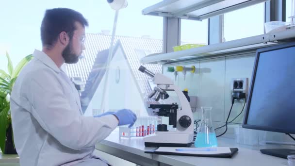 Επιστήμονας που δουλεύει στο εργαστήριο. Γιατρός που κάνει μικροβιολογική έρευνα. Βιοτεχνολογία, χημεία, βακτηριολογία, ιολογία, DNA και έννοια της υγειονομικής περίθαλψης. — Αρχείο Βίντεο