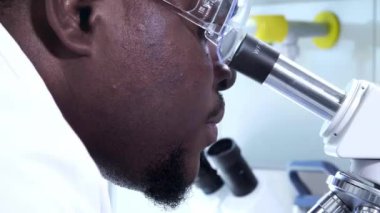 Laboratuvarda çalışan Afrikalı-Amerikalı bilim adamı. Erkek doktor mikrobiyoloji araştırması yapıyor. Biyoteknoloji, kimya, bakteriyoloji, viroloji, DNA ve sağlık hizmetleri..