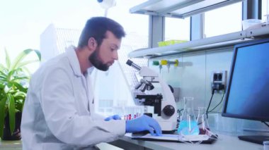 Laboratuvarda çalışan bir bilim adamı. Doktor mikrobiyoloji araştırması yapıyor. Biyoteknoloji, kimya, bakteriyoloji, viroloji, DNA ve sağlık hizmetleri kavramı.