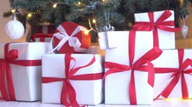 Toplar ve ışıklarla süslenmiş güzel bir Noel ağacı. Hediye kutuları, hediyeler önde..