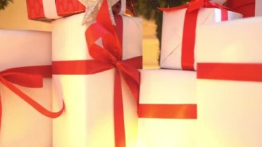 Toplar ve ışıklarla süslenmiş güzel bir Noel ağacı. Hediye kutuları, hediyeler önde..