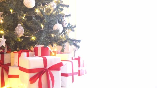 Hermoso árbol de Navidad decorado con bolas y luces. Cajas de regalos, regalos delante. Concepto de año nuevo de invierno estacional . — Vídeo de stock