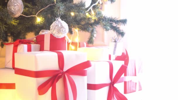 Όμορφο χριστουγεννιάτικο δέντρο διακοσμημένο με μπάλες και φώτα. Παρουσιάστε κουτιά, δώρα μπροστά. — Αρχείο Βίντεο