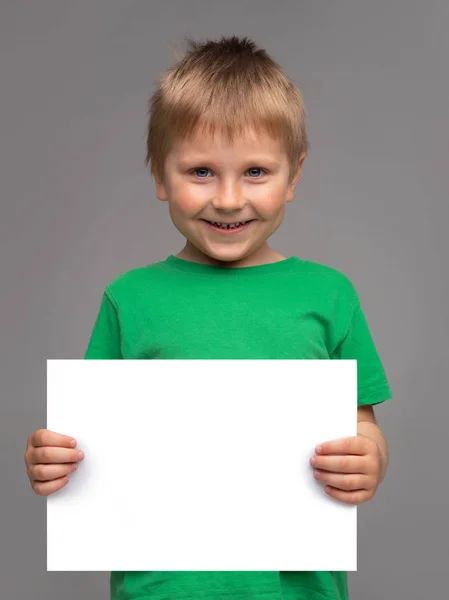 Porträtt av glad leende pojke i grön t-shirt. Attraktiv kille i studion. Begreppet barndom. — Stockfoto