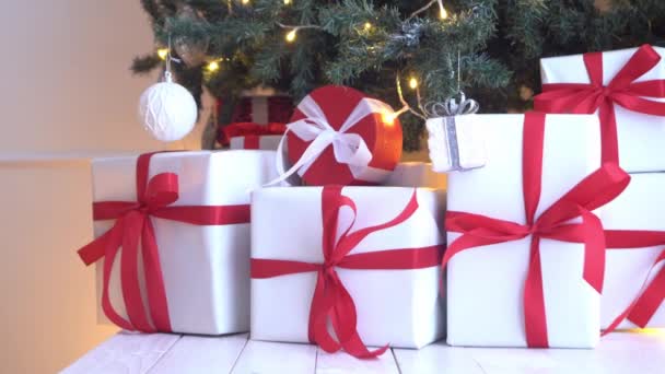 Hermoso árbol de Navidad decorado con bolas y luces. Cajas de regalos, regalos delante . — Vídeos de Stock