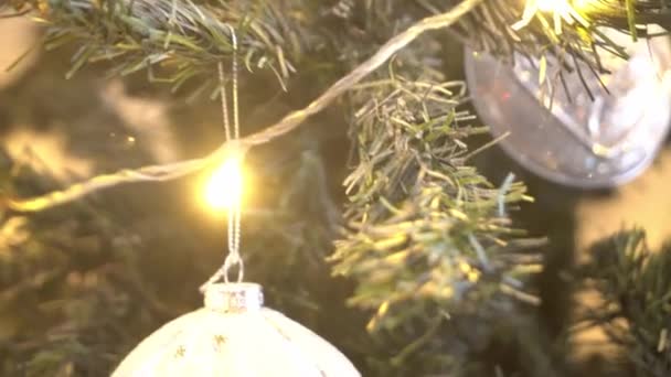 Prachtige kerstboom versierd met ballen en verlichting. Cadeau dozen, geschenken voor de deur. — Stockvideo