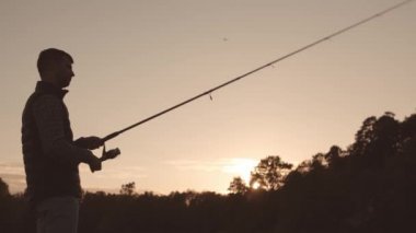 Nehirde balık yakalayan bir olta kamışlı balıkçı. Hafta sonu balıkçı. Hobi, boş zaman ve aktif yaz ve sonbahar konsepti.
