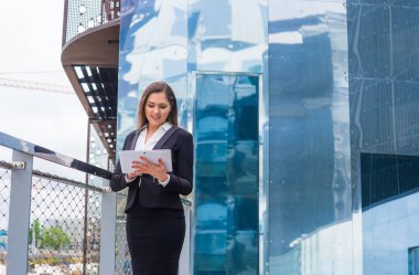 Modern ofis binasının önünde kendine güvenen bir iş kadını. İş, bankacılık, şirket ve finansal piyasa kavramı.