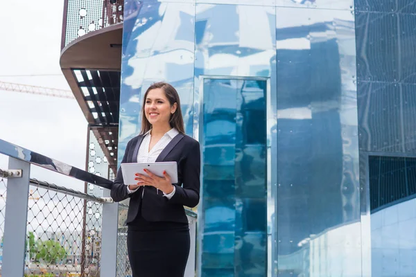 Selbstbewusste Geschäftsfrau vor einem modernen Bürogebäude. Unternehmens-, Banken-, Unternehmens- und Finanzmarktkonzept. — Stockfoto