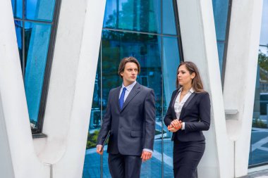 Kendine güvenen iş adamları modern ofis binasının önünde konuşuyorlar. İş adamları ve iş kadını iş görüşmesi. Bankacılık ve finans piyasası kavramı.