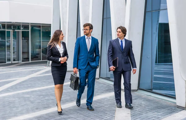 近代的なオフィスビルの前で話す自信のあるビジネスマン。ビジネスマンとビジネスウーマンはビジネスの会話をします。銀行と金融市場の概念. — ストック写真
