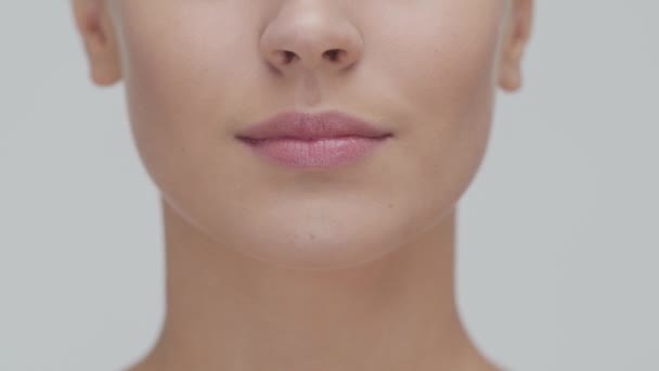 Retrato de estudio de mujer rubia joven, hermosa y natural que aplica crema para el cuidado de la piel. Levantamiento facial, cosméticos y maquillaje . — Vídeo de stock