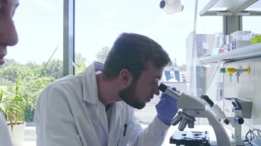 Laboratuvarda çalışan bir bilim adamı. Doktorlar tıbbi araştırma yapıyor. Laboratuvar aletleri: mikroskop, test tüpleri, ekipmanlar. Biyoteknoloji, kimya, bilim, deneyler ve sağlık konsepti.