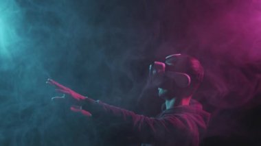 Sanal gerçeklik kaskı takmış bir adamın portresi. VR gözlüklü karanlık yüz. İnternet, darknet, oyun ve siber simülasyon.