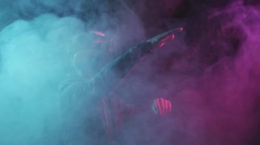 Sanal gerçeklik kaskı takmış bir adamın portresi. VR gözlüklü karanlık yüz. İnternet, darknet, oyun ve siber simülasyon.