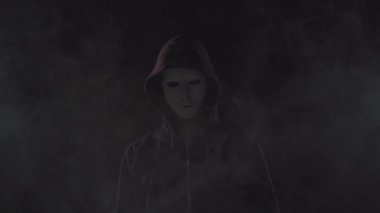 Kapüşonlu bilgisayar korsanı portresi. Karanlık bir yüz. Veri hırsızlığı, internet dolandırıcılığı, darknet ve siber güvenlik .