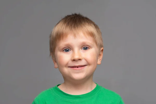 穿着绿色T恤的快乐微笑的男孩的画像。 演播室里迷人的孩子 童年概念. — 图库照片
