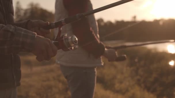 Fischerfreunde mit einer Spinnrute, die auf einem Fluss Fische fängt. Fischermänner an einem Wochenende. Hobby, Freizeit und aktives Sommer- und Herbstkonzept. — Stockvideo