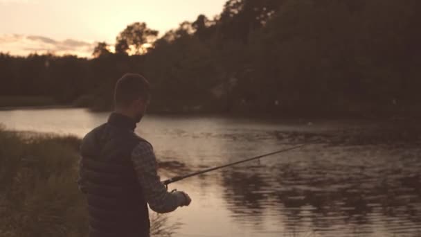 Fischer mit einer Spinnrute, die Fische auf einem Fluss fängt. Fischer an einem Wochenende. Hobby, Freizeit und aktives Sommer- und Herbstkonzept. — Stockvideo