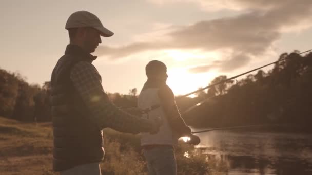 Pescatori amici con una canna da spinning cattura pesce su un fiume. Uomini Fisher in un fine settimana. Hobby, tempo libero e concetto attivo estate e autunno . — Video Stock