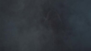 Kapüşonlu bilgisayar korsanı portresi. Karanlık bir yüz. Veri hırsızlığı, internet dolandırıcılığı, darknet ve siber güvenlik .