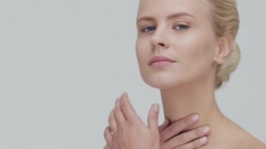 Cilt bakımı kremi süren genç, güzel ve doğal sarışın kadının stüdyo portresi. Yüz gerdirme, makyaj ve makyaj malzemeleri..