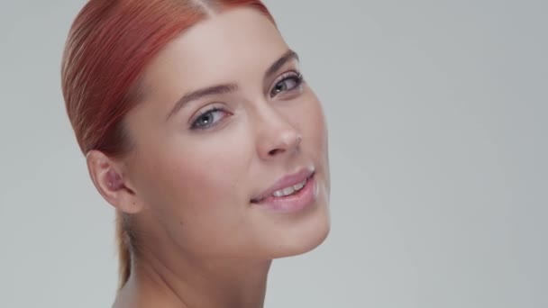 Studio portrait of young, beautiful and natural redhead woman applying skin care cream. Face lifting, cosmetics and make-up. — Stock Video