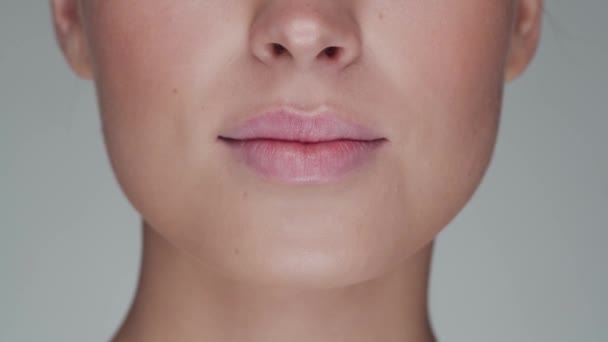 Retrato de cerca de una mujer joven, hermosa y natural abriendo la boca y sonriendo. Levantamiento facial, cosméticos y maquillaje . — Vídeos de Stock