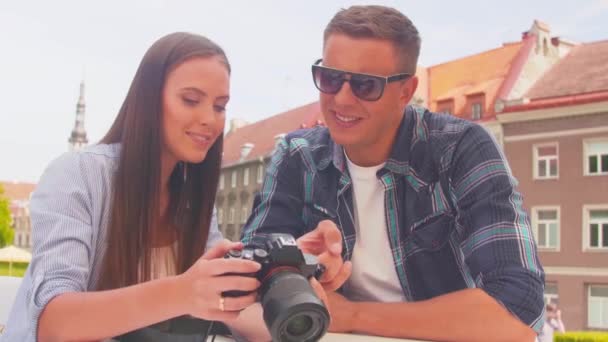 Couple of tourists traveling and exploring beautiful old town. Loving man and woman in a vacation trip. — Stockvideo