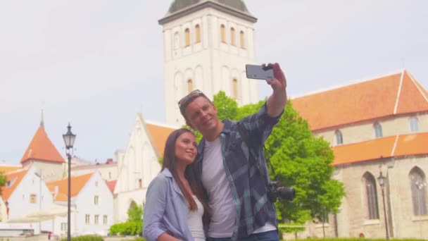 Couple of tourists traveling and exploring beautiful old town. Loving man and woman in a vacation trip. — Wideo stockowe