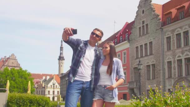 Couple of tourists traveling and exploring beautiful old town. Loving man and woman in a vacation trip. — Stock Video