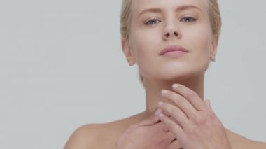 Cilt bakımı kremi süren genç, güzel ve doğal sarışın kadının stüdyo portresi. Yüz gerdirme, makyaj ve makyaj malzemeleri..