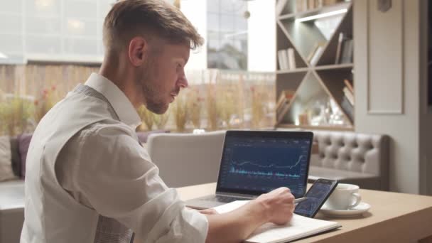 Empresario sentado y trabajando en un café. Hombre usando dispositivos informáticos. Negocios y emprendimiento . — Vídeo de stock