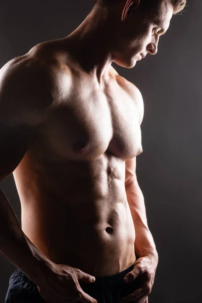 Homme de bodybuilder fort, en forme et sportif sur fond sombre. Sport et fitness . — Photo