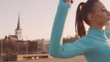 Genç, güzel ve sportif bir kadın dışarıda akşam antrenmanı yapıyor. Şehir günbatımı geçmişi. Spor ve spor konsepti.