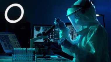 Laboratuvar ekipmanları, mikroskoplar ve test tüpleri kullanarak araştırma laboratuarında çalışan koruyucu giysi ve maskeler giyen bilim adamları. Coronavirus 2019-ncov tehlikesi, ilaç keşfi, bakteri bilimi ve virüs bilimi