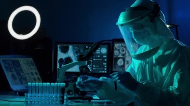 Laboratuvar ekipmanları, mikroskoplar ve test tüpleri kullanarak araştırma laboratuarında çalışan koruyucu giysi ve maskeler giyen bilim adamları. Coronavirus 2019-ncov tehlikesi, ilaç keşfi, bakteri bilimi ve virüs bilimi