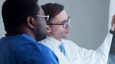 Doktor ve cerrah pencerenin yanında röntgene bakıyor. Hastanedeki sağlık çalışanları. Gün ışığı. Sağlık, tıp, takım çalışması kavramları.